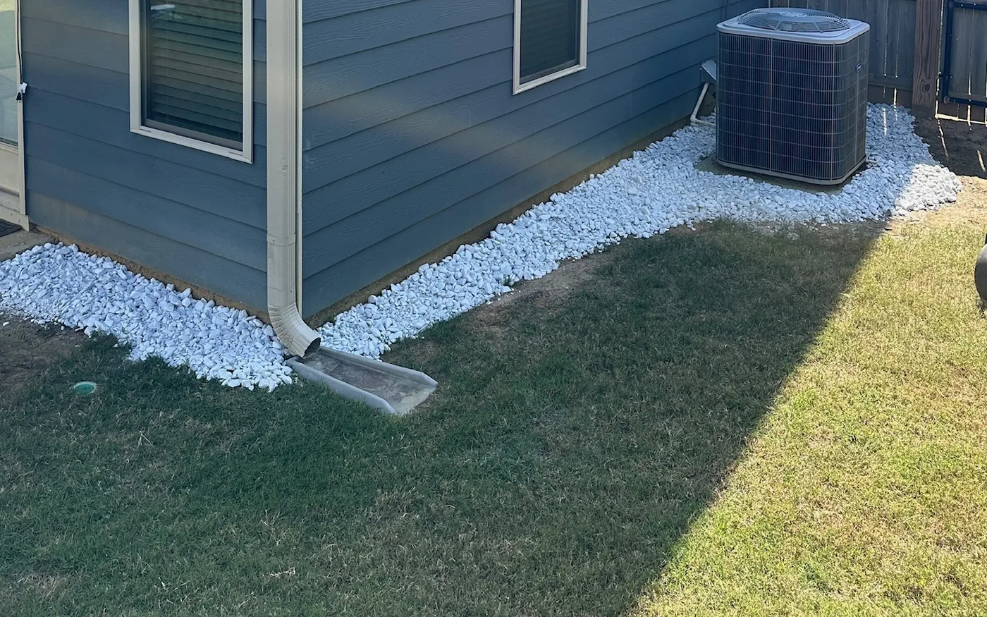 Crisp white rock border installed along the home's foundation and corner