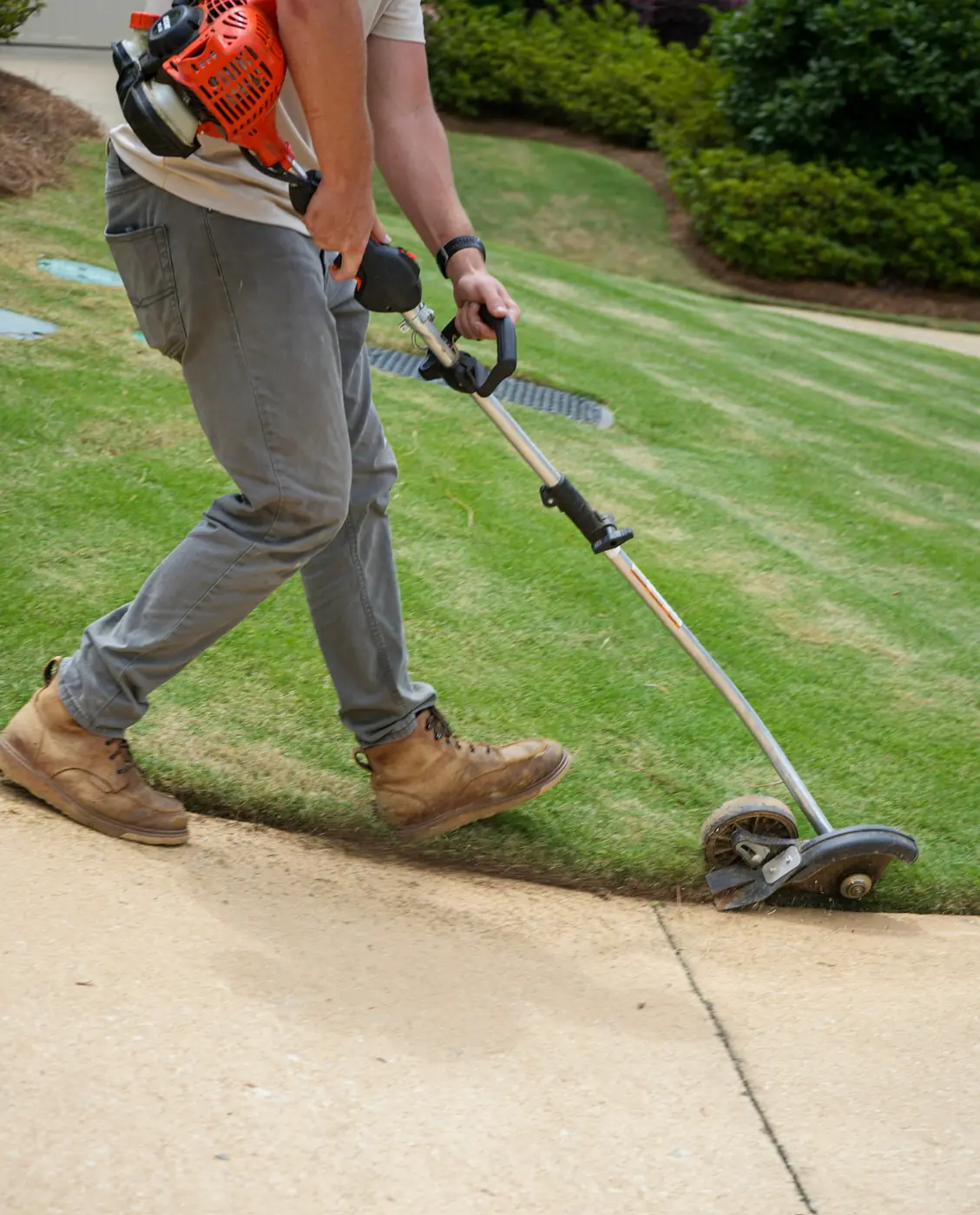 Edging a lawn edge along a concrete walkway with a string trimmer