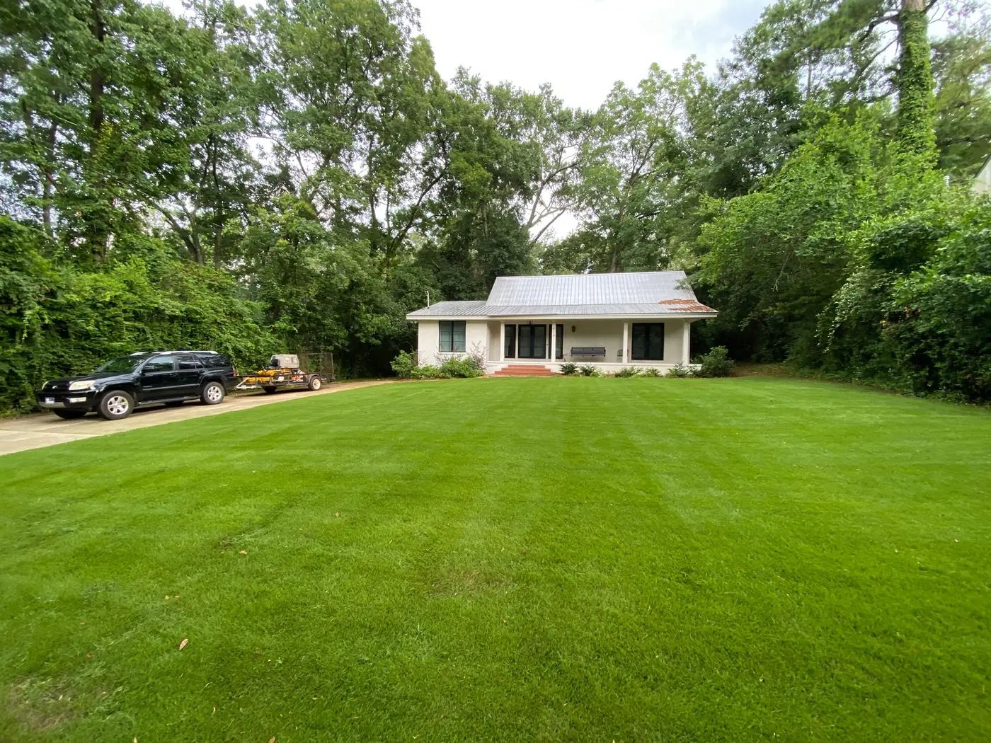 A white ranch home with a freshly striped front lawn in Auburn