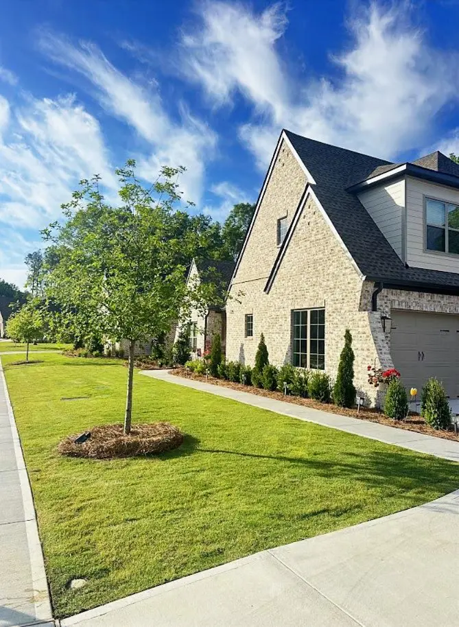 Fresh mulch and pine straw beds framing a manicured front lawn