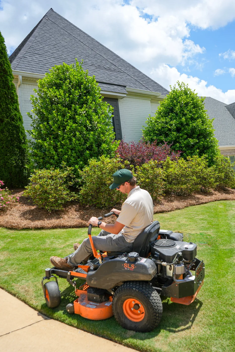 Zero-turn mower working along fresh pine straw beds